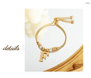 Detail van verstelbare gouden armband met een kristal ingelegde letter F hanger
