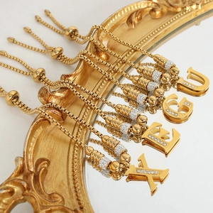 Gouden verstelbare letterarmband met strass-accenten op luxe vintage spiegeldecor