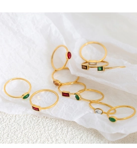 Detailed macro shot of minimalist gold rings featuring colorful geometric zircon stones