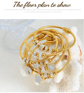 Detalle de pulseras de cadena de serpiente doradas con dijes de estrella y corazón