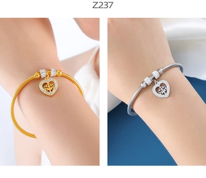 Detalle de pulsera de cadena de serpiente con colgante de corazón árbol de la vida