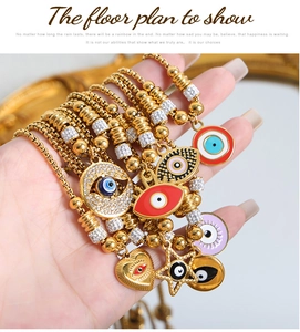 Macro detail of 18K gold-plated bracelets featuring colorful enamel Evil Eye charms and beads