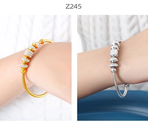 Detalle de pulseras de cadena de serpiente en oro y plata con anillos de cristales finos