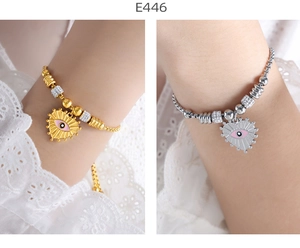 Detailed view of gold and silver heart bracelets with evil eye pendants and bead chains