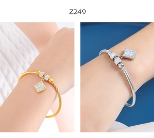 Vista macro de pulsera de cadena de serpiente oro y plata con colgantes cuadrados de pavé