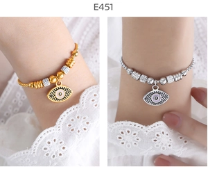 Detail of 18K gold and silver evil eye beaded bracelets with layered crystal accents