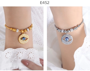 Detail of gold and silver Evil Eye chain bracelets with sparkling diamond accents