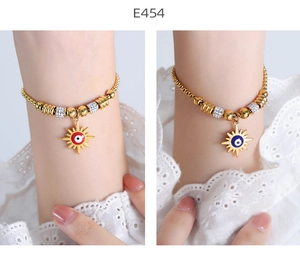 Detail of 18K gold-plated beaded bracelets with red and blue evil eye charms and crystals