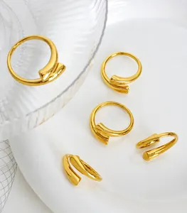 Primer plano de cinco anillos abiertos bañados en oro minimalistas en un plato de cerámica