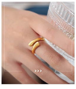 Primer plano de un anillo ajustable dorado minimalista con diseño fluido irregular pulido