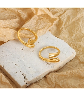 Anillo abierto dorado minimalista con extremos redondos sobre mármol blanco pulido