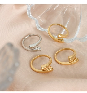 Anillos abiertos minimalistas en oro y plata expuestos en elegante tela de raso rosa