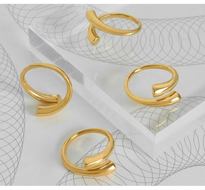 Detalle de anillos de lujo con diseño de espiral irregular en acabado dorado pulido