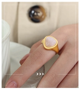 Detail of a vintage 18k gold-plated ring with a triangular pink quartz stone on hand