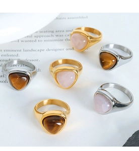 Macro detail of triangle tiger eye stone rings in gold and silver stainless steel settings