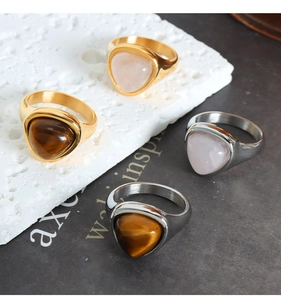 Detailed view of 18k gold and silver titanium rings with tiger eye and rose quartz stones