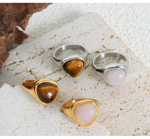 Detailed shot of geometric titanium rings with natural tiger eye and rose quartz stones