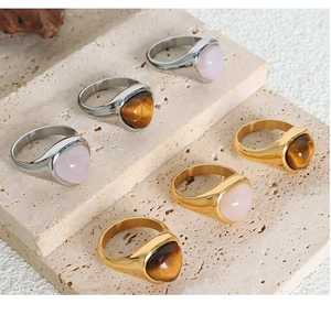 Tiger eye and rose quartz signet rings in gold and silver finish on stone display