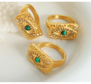 Dettaglio di anelli occhio di bue placcati oro 18K con pietra verde e metallo martellato