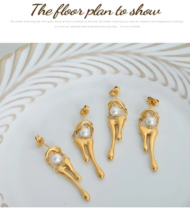 Dettaglio di orecchini vintage in oro 18 carati dal design fluido con perle bianche