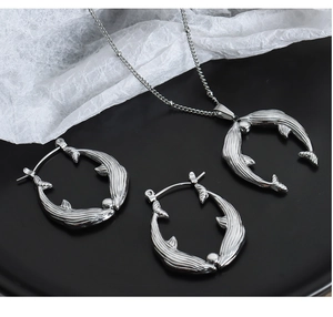 Vue détaillée d'une parure collier et boucles d'oreilles queue de baleine en argent poli
