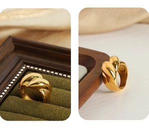 Detailed view of heavy twisted geometric ring in 18k gold finish on velvet display