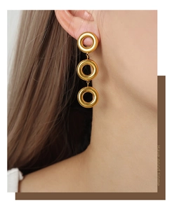 Close-up of triple-layered geometric gold hoop earrings worn on model for a modern look