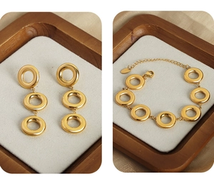 Detailed set of golden geometric hoop earrings and matching circle link chain bracelet
