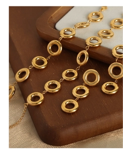 Macro shot of 18k gold plated round geometric links showing polished metallic texture