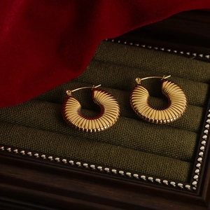 Retro 18k vergulde U-vormige gestreepte oorbellen op groen fluwelen display
