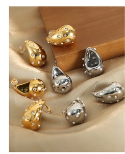 Detailed macro of teardrop earrings with sparkling rhinestones and pearls on satin