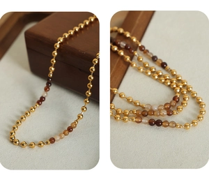 Detalle macro de cuentas de piedra natural y cuentas de acero inoxidable chapado en oro 18k