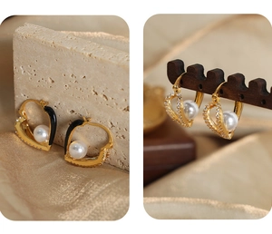 Detail of hollow heart earrings with white pearls, black enamel, and paved zircon stones