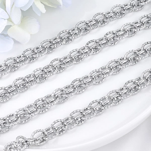 Textured stainless steel oval link chain necklace with diamond-cut pattern on white tray