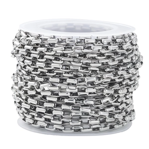 Macro shot of silver stainless steel rectangular link chain on a white spool for DIY jewelry
