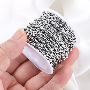 Hand holding a roll of silver stainless steel twisted link chain for DIY jewelry making