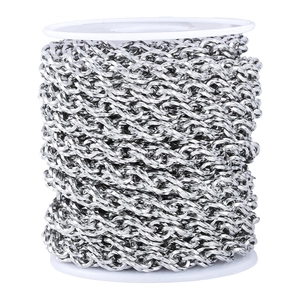 Macro detail of silver stainless steel oval twist chain wound on a white plastic spool