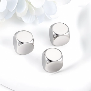 Three polished stainless steel square beads with mirror finish from a 45-degree angle