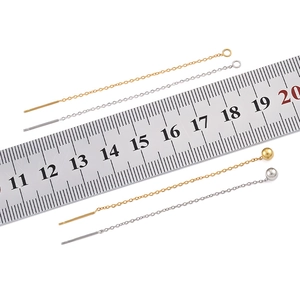 Detail of gold and silver stainless steel ear threads with ruler showing 10cm length