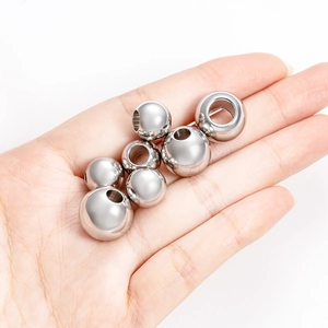 Perles d'espacement en acier inoxydable poli pour bijoux montrées sur main
