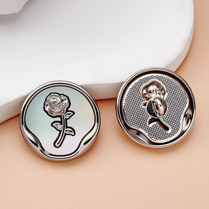Detailed view of silver rose metal buttons with front embossed and back textured finish