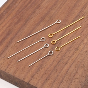 Detailed view of various lengths of gold and silver eye pins for DIY jewelry making