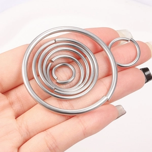 Polished stainless steel jump rings for DIY jewelry making held in hand for scale