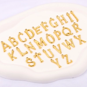 Detailed view of 18K gold plated stainless steel A-Z pendants with bamboo texture