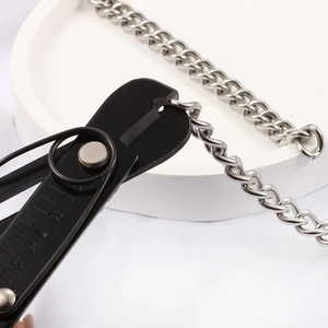 Pince à bijoux en acier noir coupant une grosse chaîne argentée pour création DIY