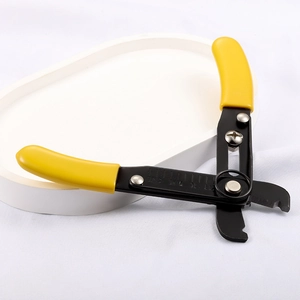 Pince à dénuder manuelle avec poignées jaunes ergonomiques sur plateau blanc minimaliste