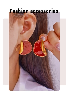 Detail von roten Emaille-Ohrringen mit 18 Karat Goldbeschichtung am Model getragen