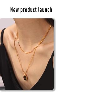 Double layered necklace with gold snake chain and oval tiger eye stone pendant
