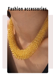 Detail of gold titanium steel spring coil necklace showing layered metallic texture