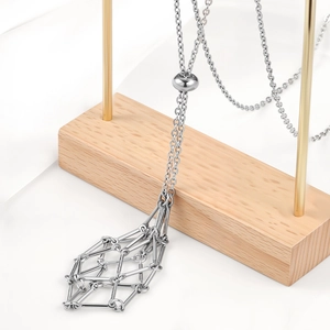 Silver woven mesh cage pendant necklace with adjustable chain on a premium display stand